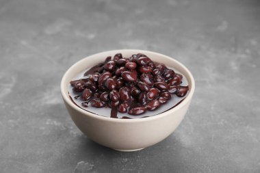 Bowl of canned kidney beans on grey table