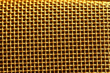 Metal mesh of golden microphone as background, closeup