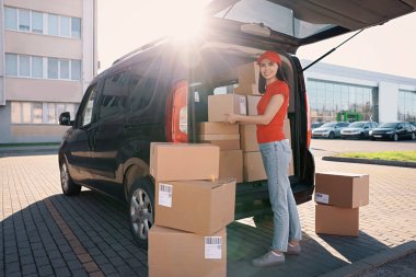 Kurye teslimat minibüsünden paket alıyor.