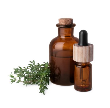Bottles of thyme essential oil and fresh plant isolated on white