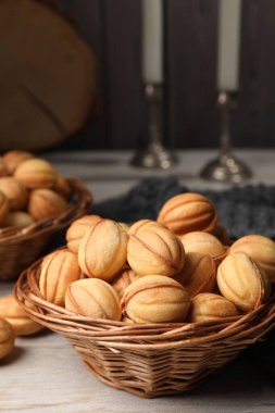 Bowls of delicious nut shaped cookies on white wooden table, closeup