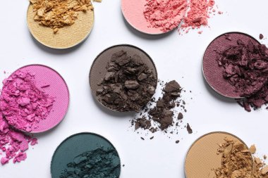 Different crushed eye shadows on white background, flat lay. Professional makeup product