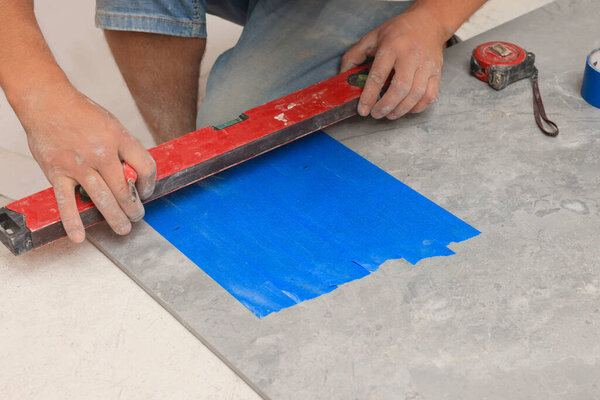 Worker making socket hole in tile indoors, closeup