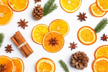 Flat lay composition with dry orange slices, anise stars, cinnamon sticks and fir cones on white background