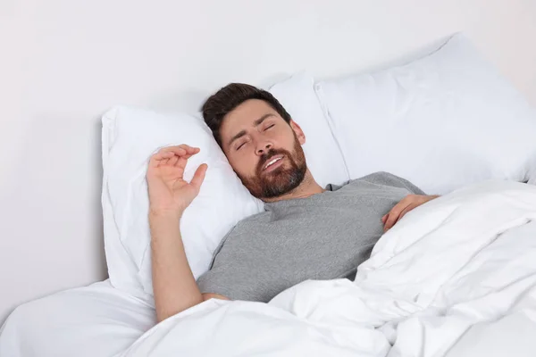 Man sleeping on comfortable pillows in bed at home