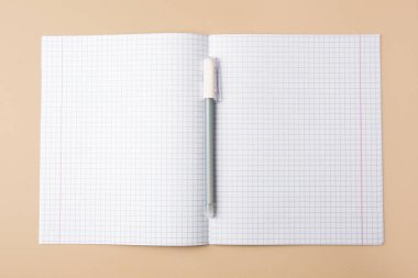 Copybook with erasable pen on beige background, top view