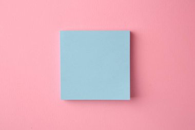 Blank paper note on pink background, top view