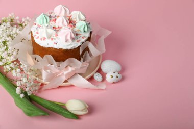 Traditional Easter cake with meringues and painted eggs on pink background, space for text