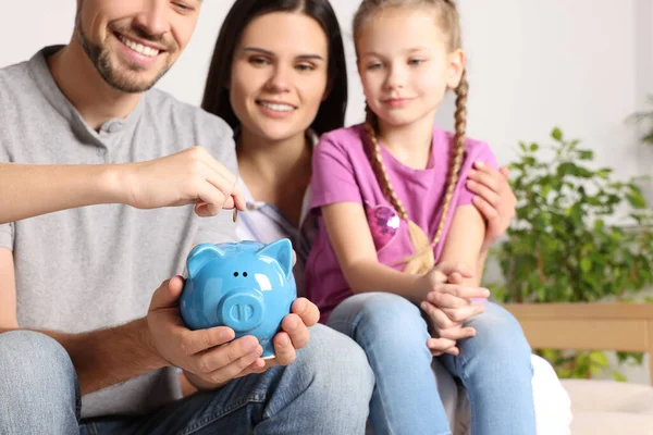 Happy Family Putting Coin Piggy Bank Home Closeup — Stockfoto