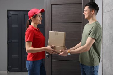 Courier giving parcel to customer at house entrance