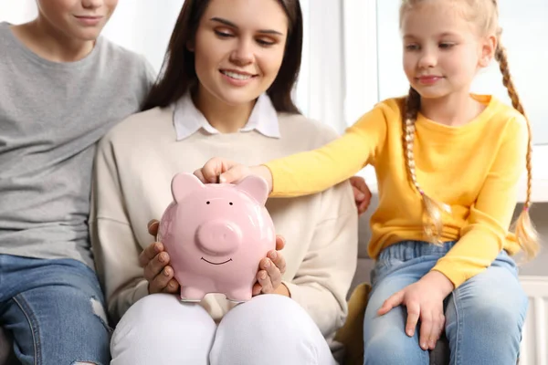 Happy Family Putting Coin Piggy Bank Home Closeup — Stockfoto