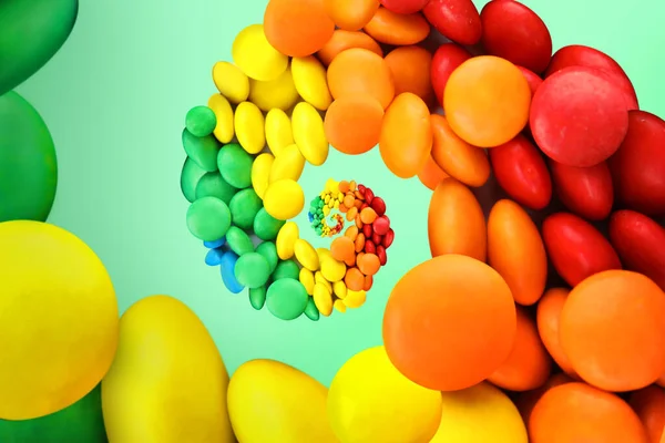Whirl of colorful candies on mint color background