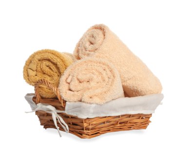 Wicker basket with rolled bath towels isolated on white
