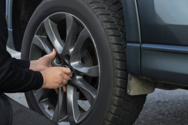 Man changing tire on car outdoors, closeup