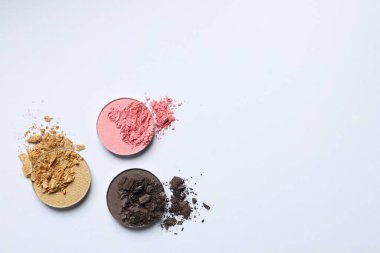 Different crushed eye shadows on white background, flat lay. Space for text