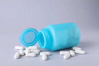 Açık gri arka planda antidepresanlar ve tıbbi kavanoz.