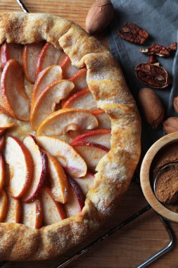 Delicious apple galette, cinnamon and pecans on table, flat lay