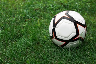 New soccer ball on fresh green grass outdoors, space for text