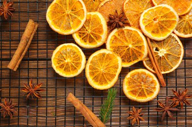 Flat lay composition with dry orange slices, anise stars and cinnamon sticks on wooden table
