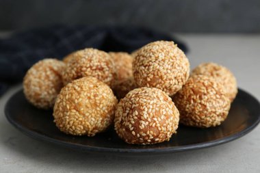Delicious sesame balls on light grey table, closeup