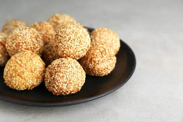 Delicious sesame balls on light grey table, closeup. Space for text