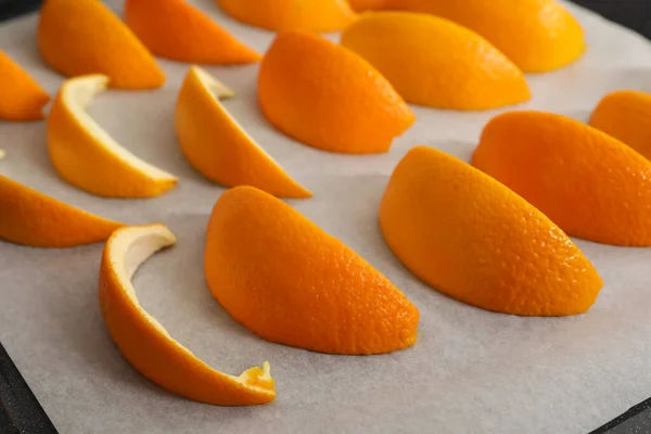 Fresh orange peels on white parchment paper, closeup