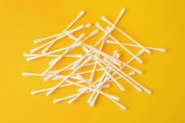 Sarı arka planda birçok temiz pamuk tomurcukları, düz uzanmış