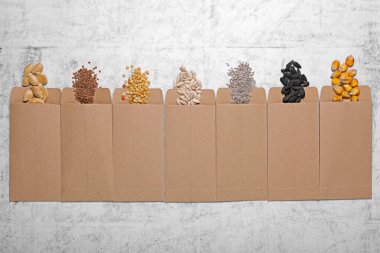 Many different vegetable seeds on light grey table, flat lay