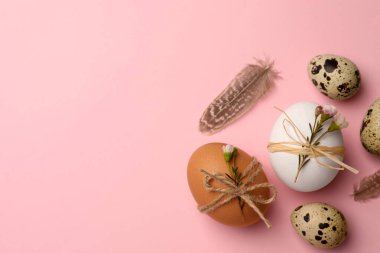 Festively decorated eggs on pink background, flat lay and space for text. Happy Easter
