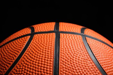 Siyah arka planda turuncu basketbol topu, yakın plan.