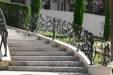 Staircase with beautiful ornate handrails outdoors on sunny day