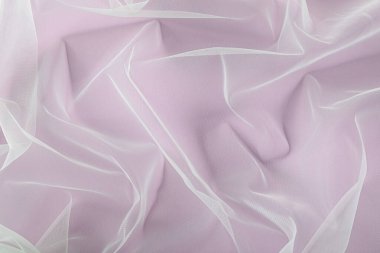 Beautiful tulle fabric on lilac background, top view