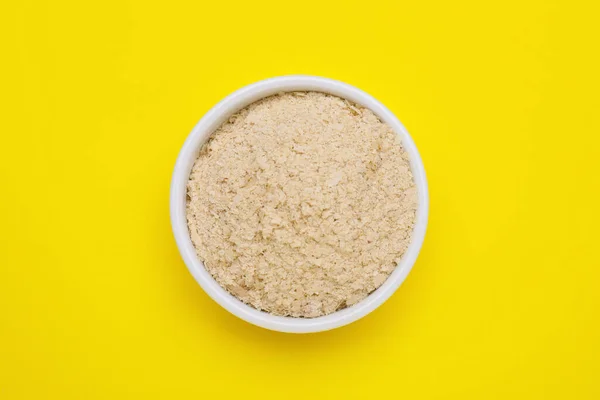 Beer yeast flakes on yellow background, top view