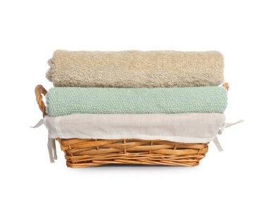 Wicker basket with folded bath towels isolated on white