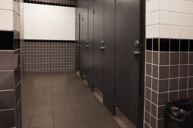 Public toilet interior with stalls and tiled walls