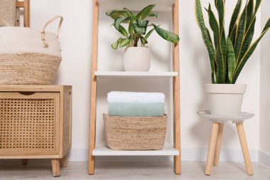 Beyaz duvarın yanındaki dekoratif merdivende yumuşak havlular.