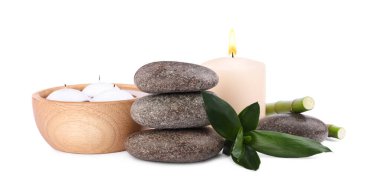 Spa stones, candles and bamboo on white background