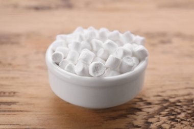 Bowl with delicious marshmallows on wooden table