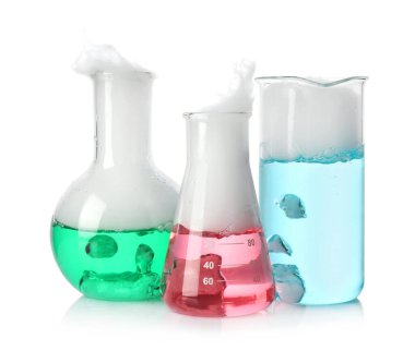 Laboratory glassware with colorful liquids and steam isolated on white. Chemical reaction