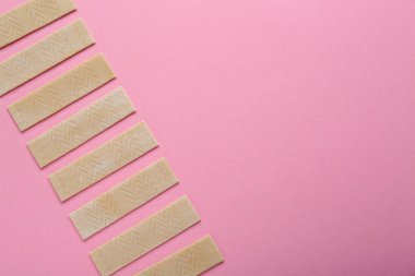 Many sticks of tasty chewing gum on pink background, flat lay. Space for text