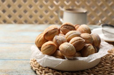 Bowl of delicious nut shaped cookies on grey wooden table. Space for text