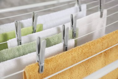 Clean terry towels hanging on drying rack, closeup