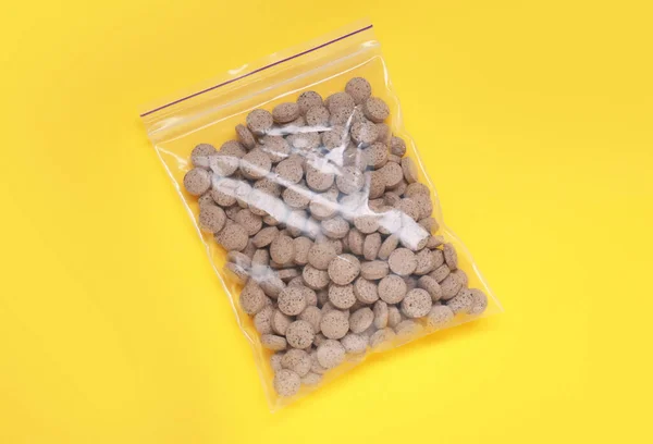 Beer yeast pills on yellow background, top view