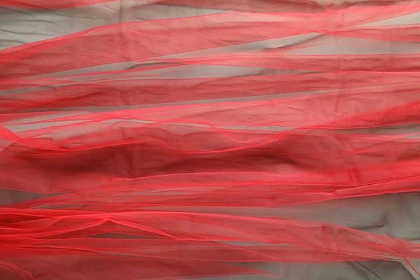 Beautiful red tulle fabric as background, top view