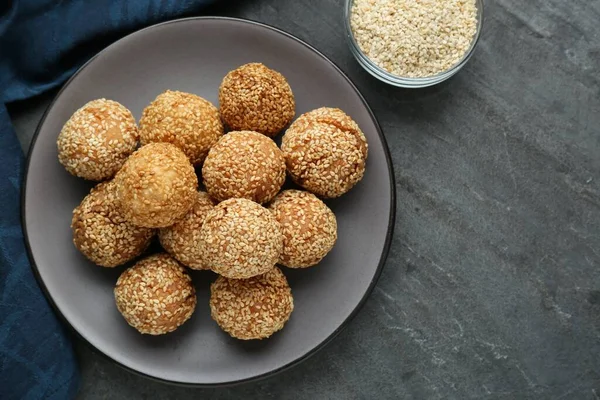 Delicious sesame balls on grey table, top view. Space for text