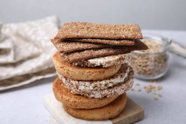 Stack of rye crispbreads, rice cakes and rusks on white table