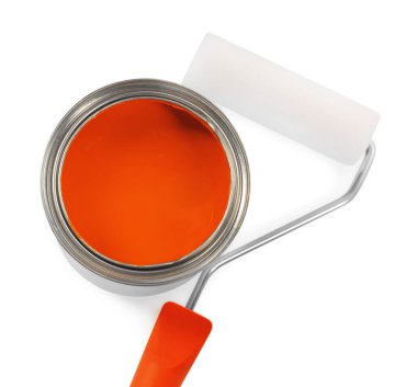 Can of orange paint and roller on white background, top view