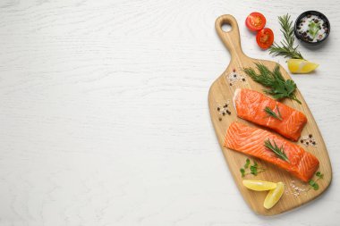Fresh salmon and ingredients for marinade on white wooden table, top view. Space for text