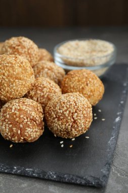 Many delicious sesame balls on grey table, closeup