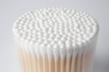 Open container with cotton buds on white background, closeup